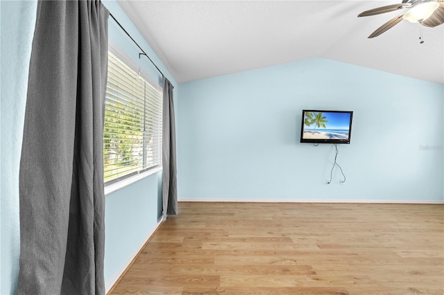 empty room featuring ceiling fan, lofted ceiling, and light hardwood / wood-style flooring