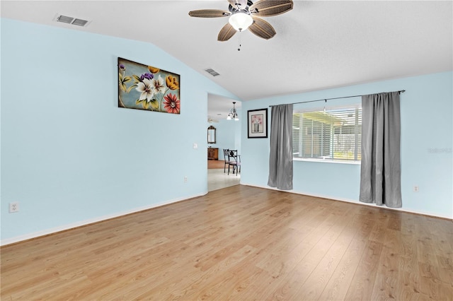 spare room with light hardwood / wood-style floors, lofted ceiling, and ceiling fan with notable chandelier