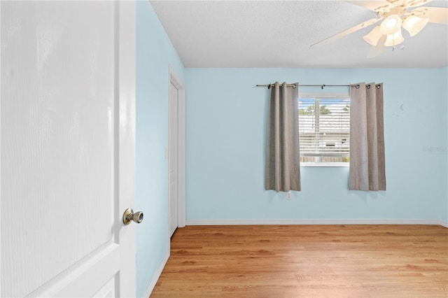 unfurnished room with a textured ceiling, light hardwood / wood-style floors, and ceiling fan