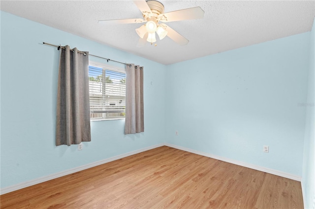 empty room with ceiling fan, a textured ceiling, and light wood-type flooring