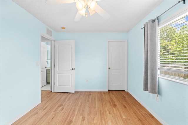 unfurnished bedroom with ceiling fan and light wood-type flooring