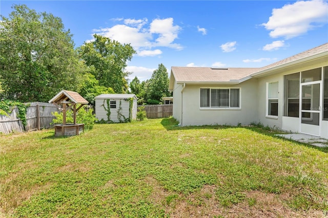 view of yard with a sunroom and a storage shed