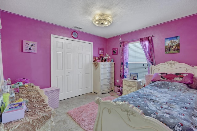 carpeted bedroom with a textured ceiling and a closet