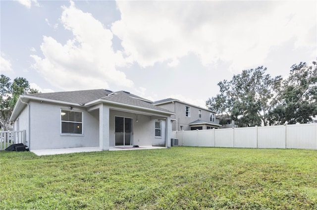 rear view of house featuring central air condition unit, a patio area, and a lawn