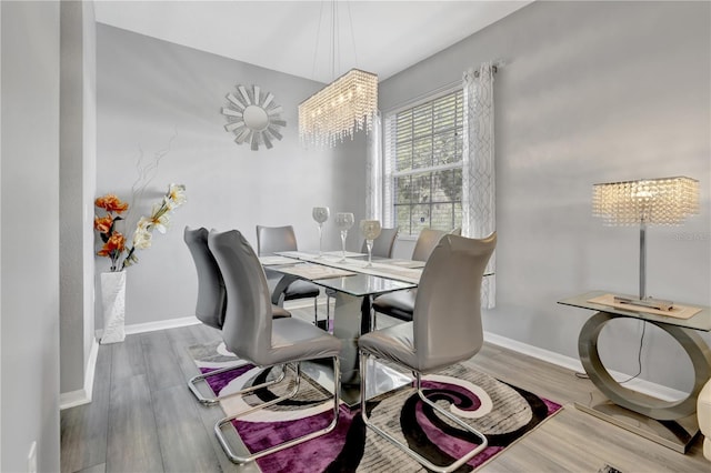 dining room featuring wood-type flooring and an inviting chandelier