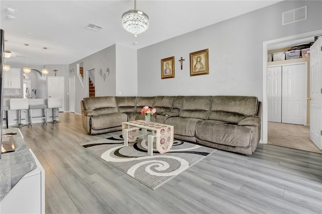 living room with a notable chandelier and light hardwood / wood-style flooring