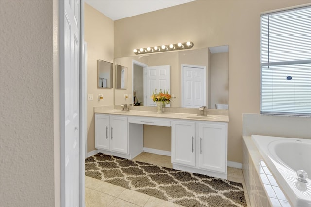 bathroom with tile patterned floors, tiled tub, and vanity