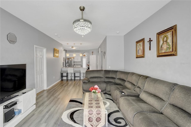 living room featuring light hardwood / wood-style flooring and a chandelier