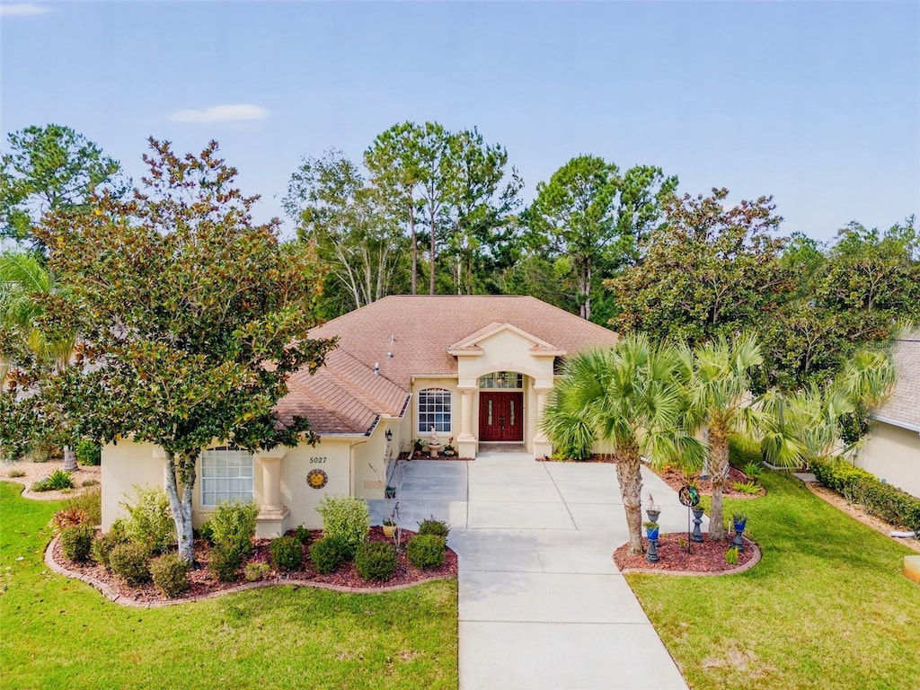 mediterranean / spanish house featuring a front lawn