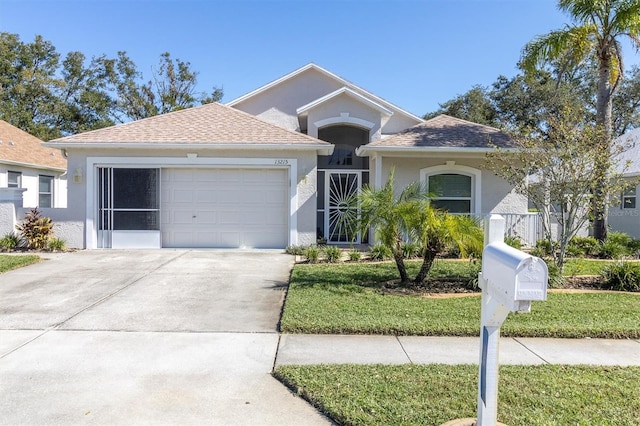 view of front of property featuring a front yard and a garage