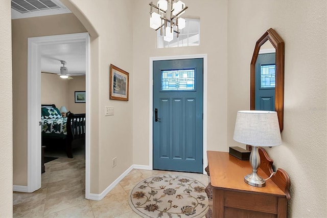 foyer entrance with an inviting chandelier and light tile patterned flooring