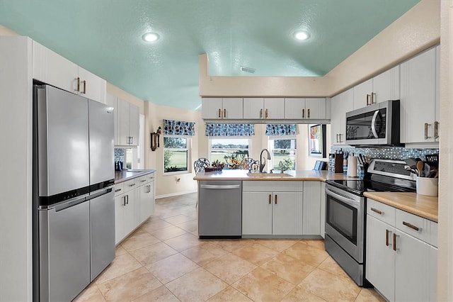 kitchen featuring sink, white cabinets, kitchen peninsula, and stainless steel appliances