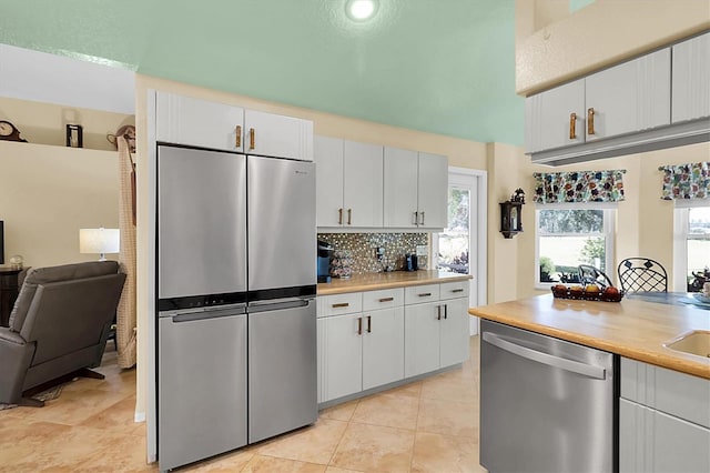 kitchen featuring white cabinets, stainless steel appliances, plenty of natural light, and backsplash