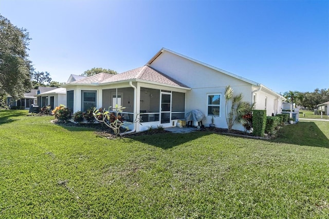 back of house featuring a yard and a sunroom