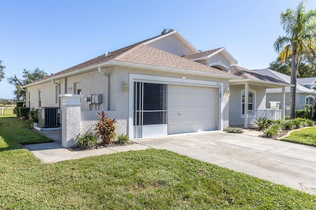 view of front of property featuring cooling unit, a garage, and a front lawn