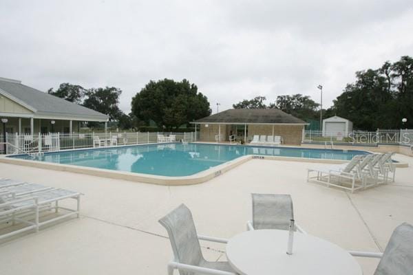 view of swimming pool with an outdoor structure and a patio