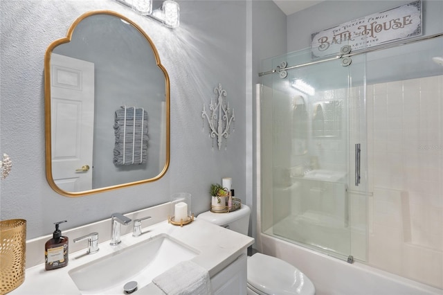 full bathroom featuring shower / bath combination with glass door, vanity, and toilet