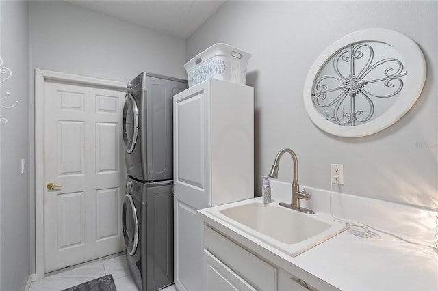 washroom featuring stacked washer and dryer, cabinets, and sink