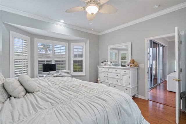 bedroom with hardwood / wood-style flooring, multiple windows, ornamental molding, and ceiling fan