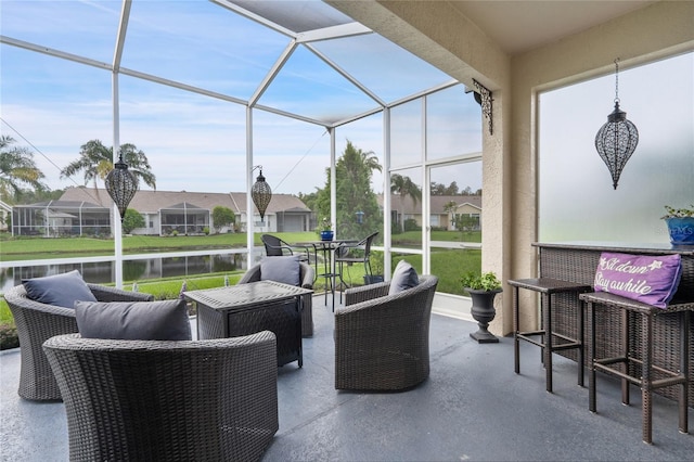 view of patio / terrace featuring a water view and glass enclosure