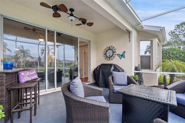 view of patio / terrace with ceiling fan, a grill, and glass enclosure