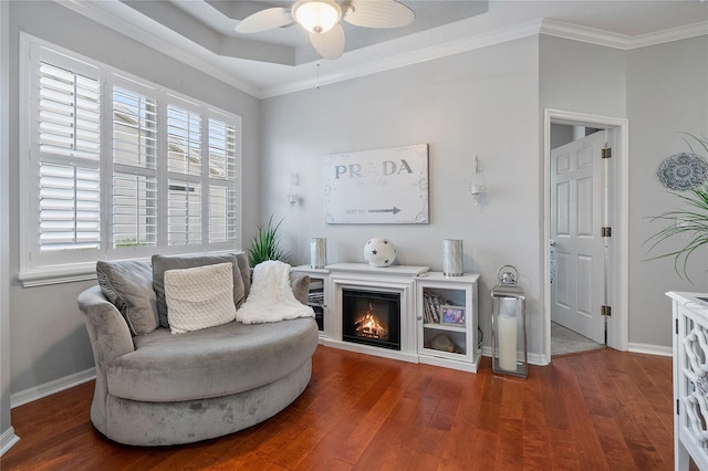 living area featuring hardwood / wood-style floors, ceiling fan, and ornamental molding