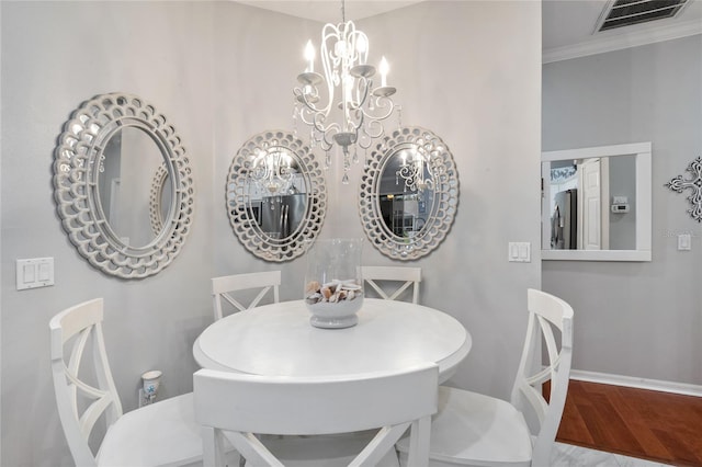 dining room featuring crown molding, an inviting chandelier, and hardwood / wood-style flooring