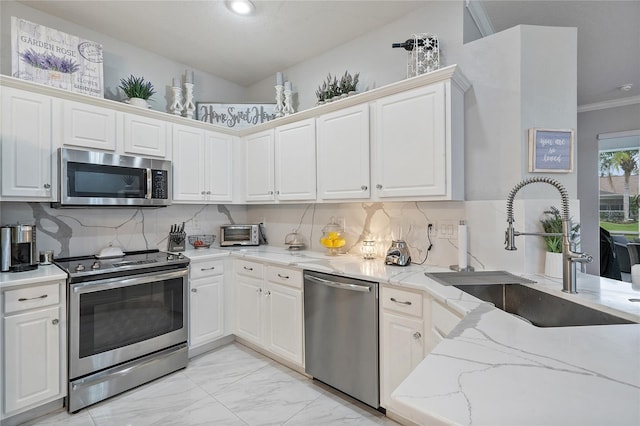 kitchen featuring white cabinetry, ornamental molding, sink, and appliances with stainless steel finishes