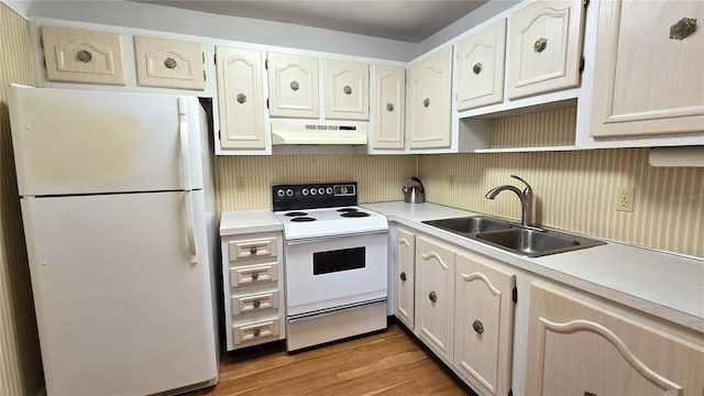 kitchen featuring white appliances, sink, and light wood-type flooring