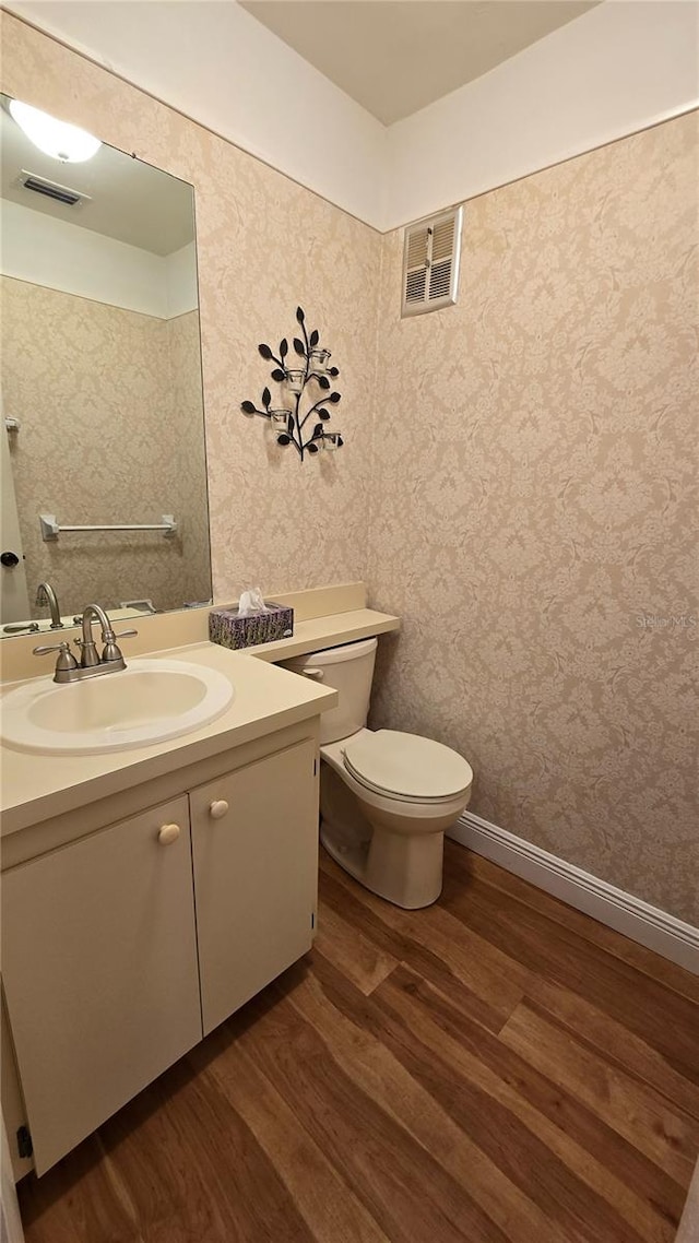 bathroom with vanity, hardwood / wood-style floors, and toilet