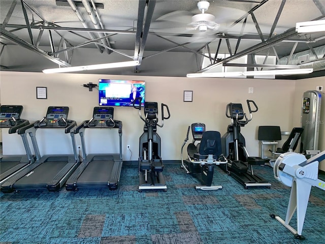 gym featuring ceiling fan and dark carpet