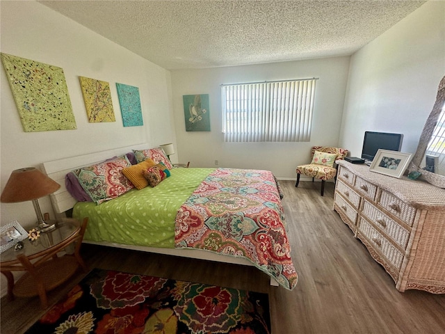 bedroom featuring wood-type flooring and a textured ceiling