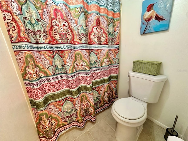 bathroom with toilet, a shower with curtain, and tile patterned floors