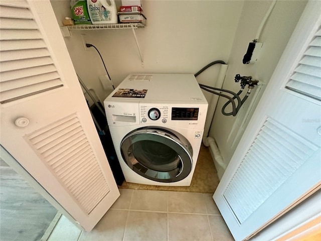 laundry room featuring washer / clothes dryer and light tile patterned floors