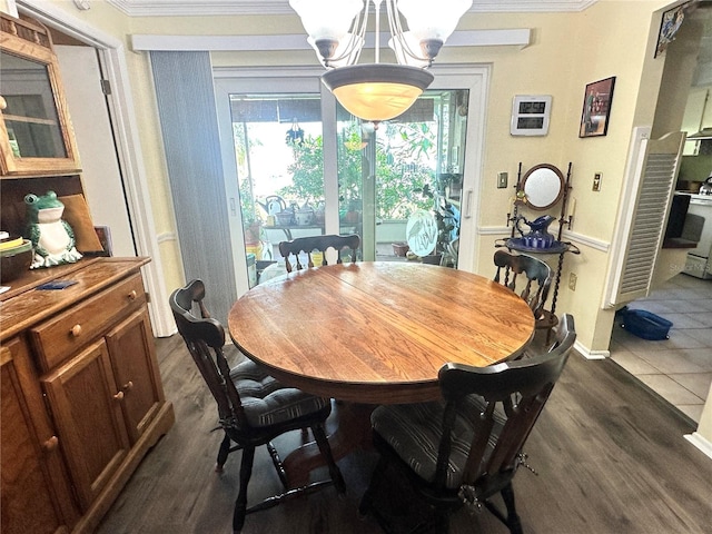 dining area with ornamental molding, an inviting chandelier, and dark hardwood / wood-style floors