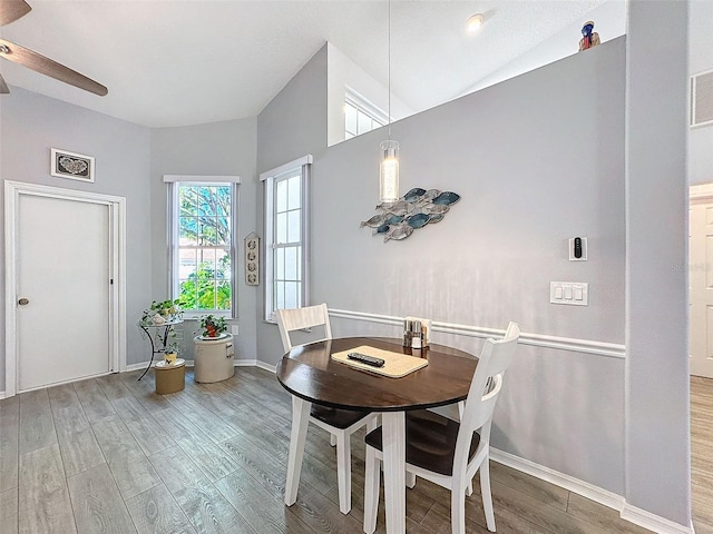 dining area featuring lofted ceiling, wood-type flooring, and ceiling fan