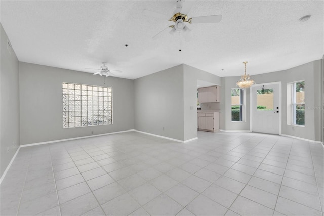 unfurnished living room featuring a textured ceiling, ceiling fan with notable chandelier, and light tile patterned floors