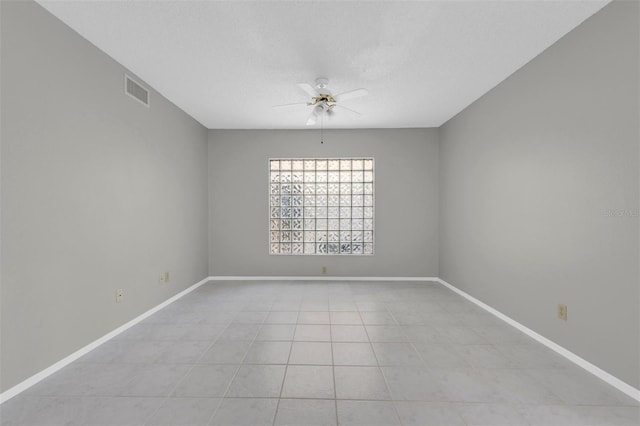 tiled empty room featuring a textured ceiling and ceiling fan