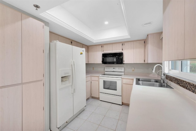 kitchen featuring light brown cabinetry, sink, white appliances, and a raised ceiling