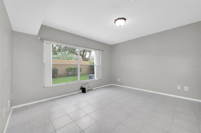 unfurnished room with a textured ceiling