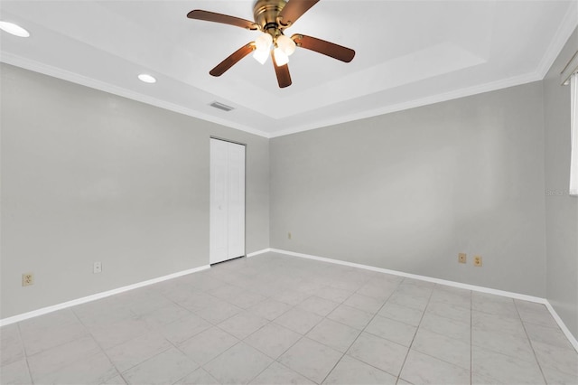 empty room featuring ornamental molding, a raised ceiling, and ceiling fan