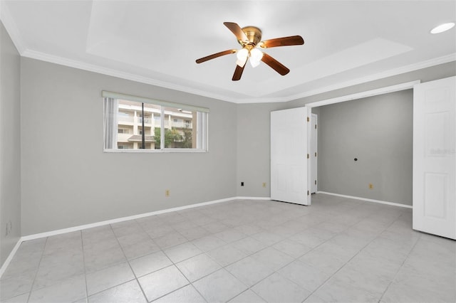 empty room featuring ornamental molding, a tray ceiling, and ceiling fan