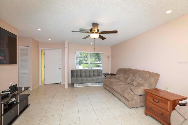 tiled living room with a textured ceiling and ceiling fan