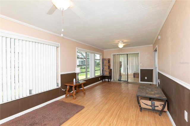 interior space featuring ornamental molding, light wood-type flooring, and ceiling fan