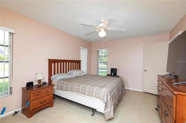 bedroom featuring multiple windows, a textured ceiling, and ceiling fan