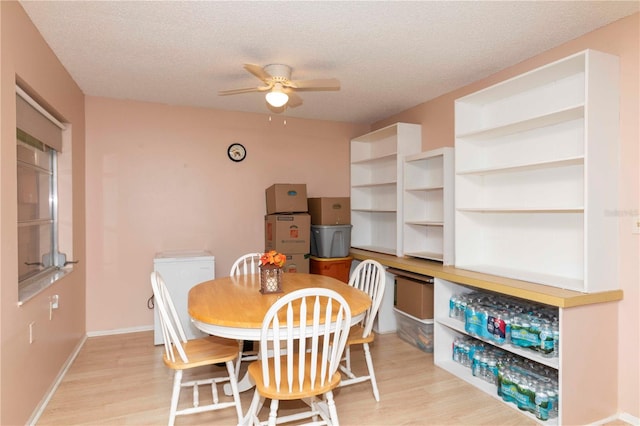 dining area featuring ceiling fan, a textured ceiling, and light hardwood / wood-style flooring