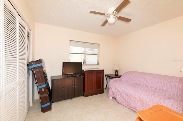 bedroom featuring a closet, ceiling fan, and a textured ceiling