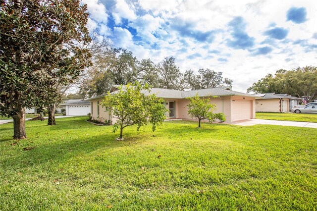 single story home featuring a front yard and a garage