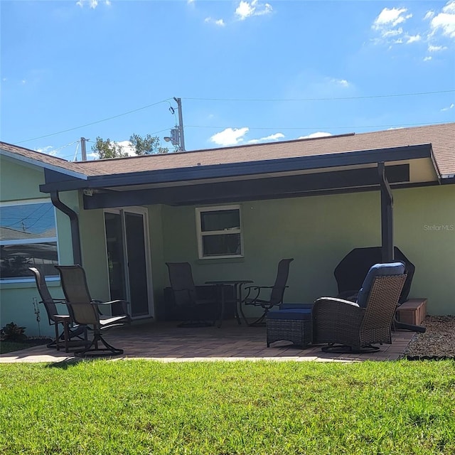 back of property featuring a patio area and a yard