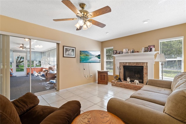 tiled living room with a brick fireplace, a textured ceiling, and ceiling fan